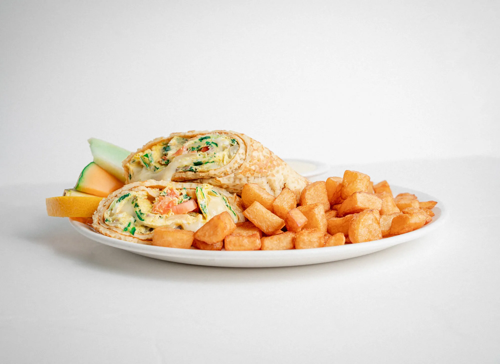 Omelette en wrap avec pommes de terre rissolées et fruits