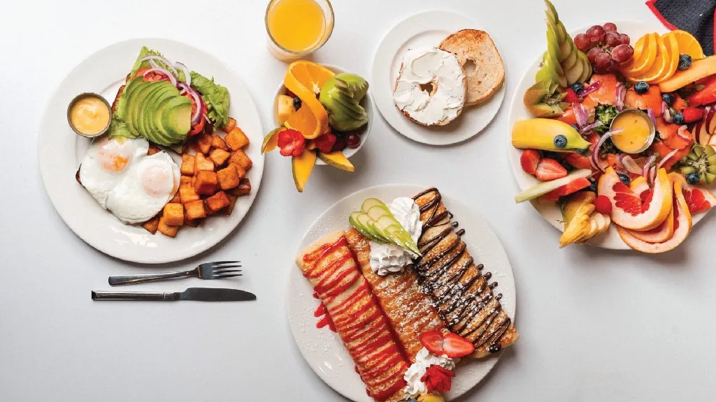 Brunch abondant : œufs, crêpes, fruits frais et saumon fumé